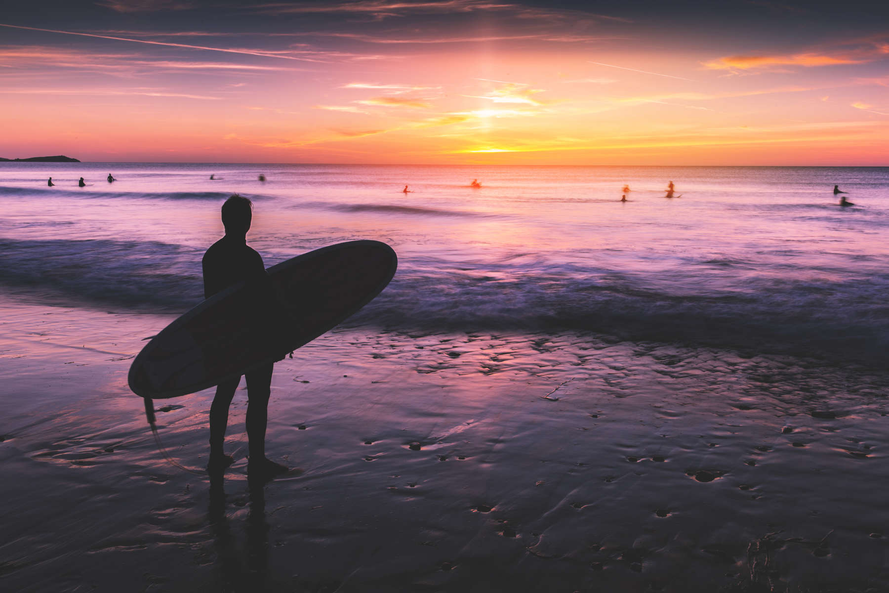 Silhouette of surfer at sunset