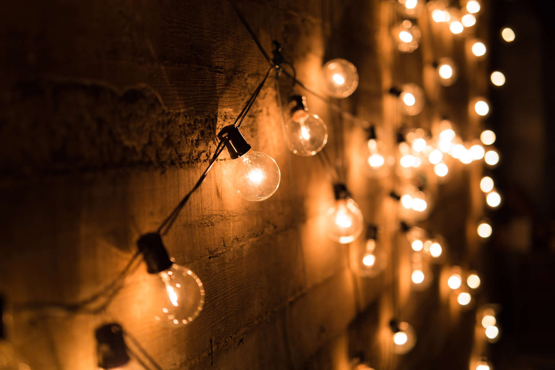 String of vintage light bulbs against a concrete wall with shall