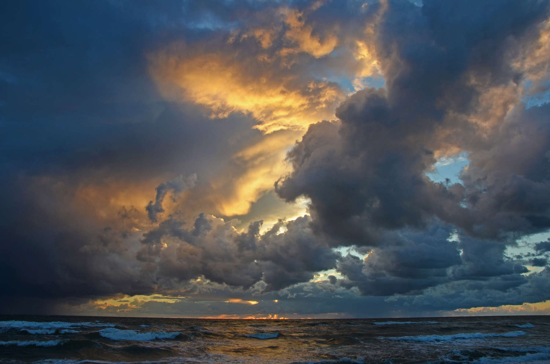 Seashore sky orange tones heavy clouds and sea waves beautiful nature bright sunset dark water