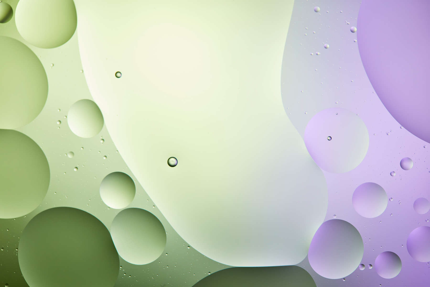 abstract background from mixed water and oil in light green and purple color