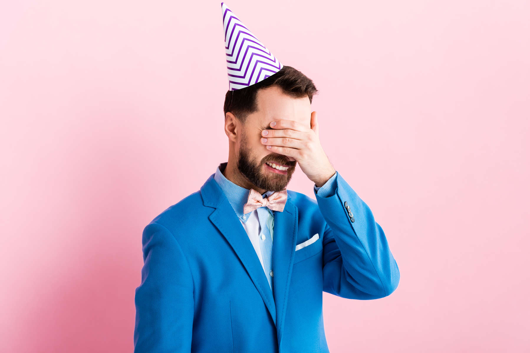 frustrated businessman covering eyes while crying isolated on pink 