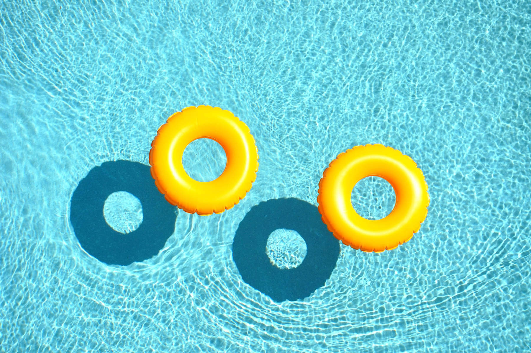 Two yellow pool floats